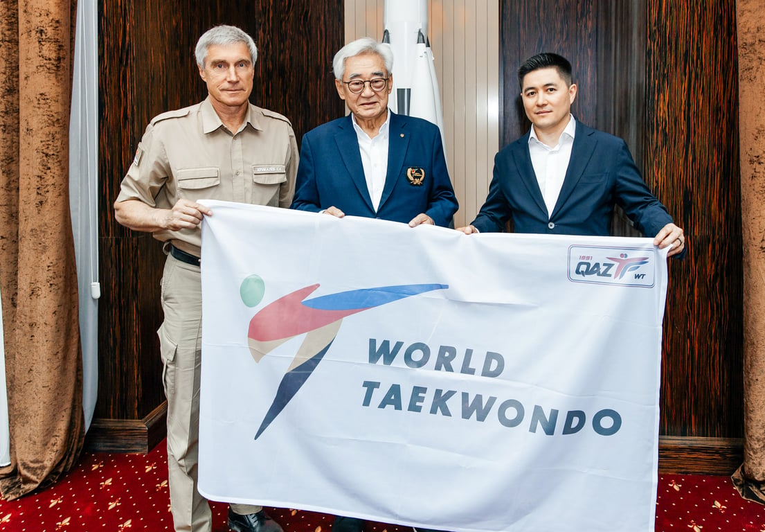 World Taekwondo President Chungwon Choue and Kazakhstan Taekwondo Federation President Kudrat Shamiyev hold the WT flag before its journey into space