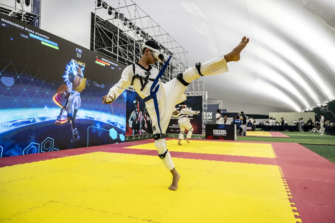 A competitor executes a kick while wearing virtual reality equipment during the Chuncheon competition